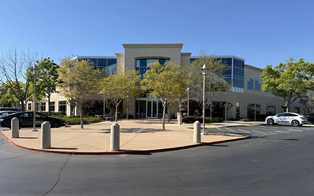 The two-story office building at 1430 Blue Oaks Blvd in Roseville under a blue sky