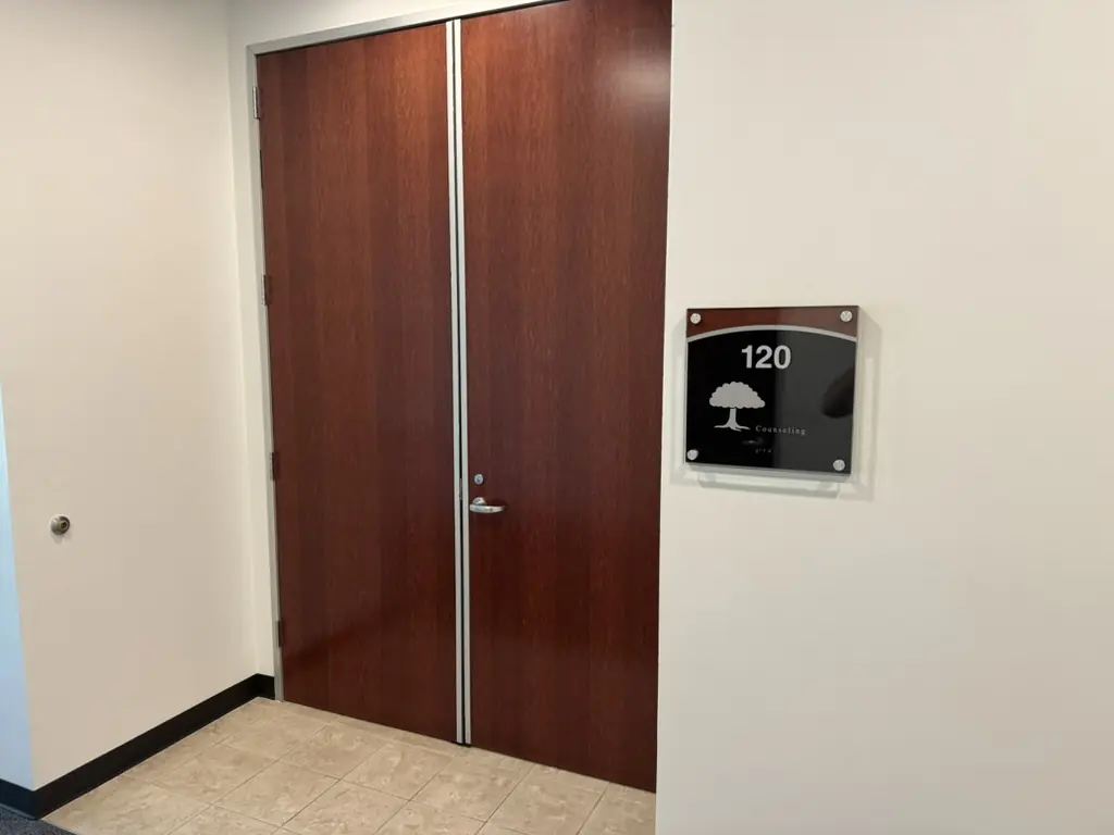 The Suite 120 sign beside a wood door at 1430 Blue Oaks Blvd